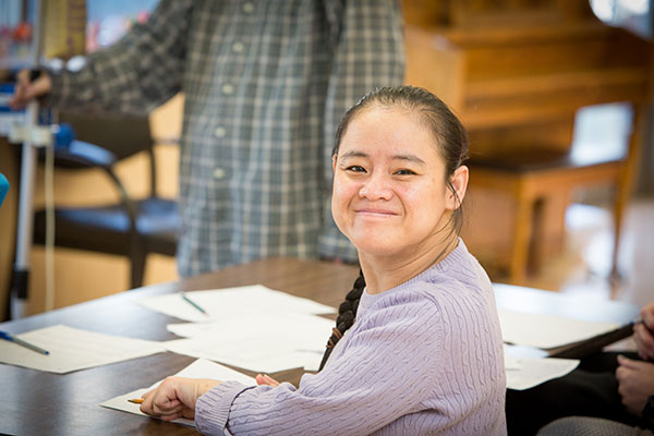 a young woman at a desk with a smile on her face